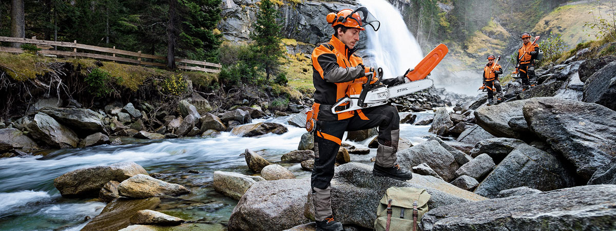 Man holding Stihl chainsaw by river