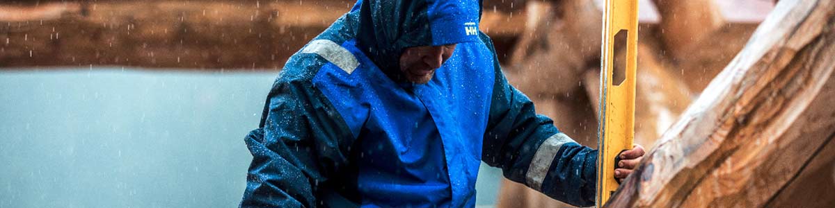 Man working in rain wearing Helly Hansen rain jacket